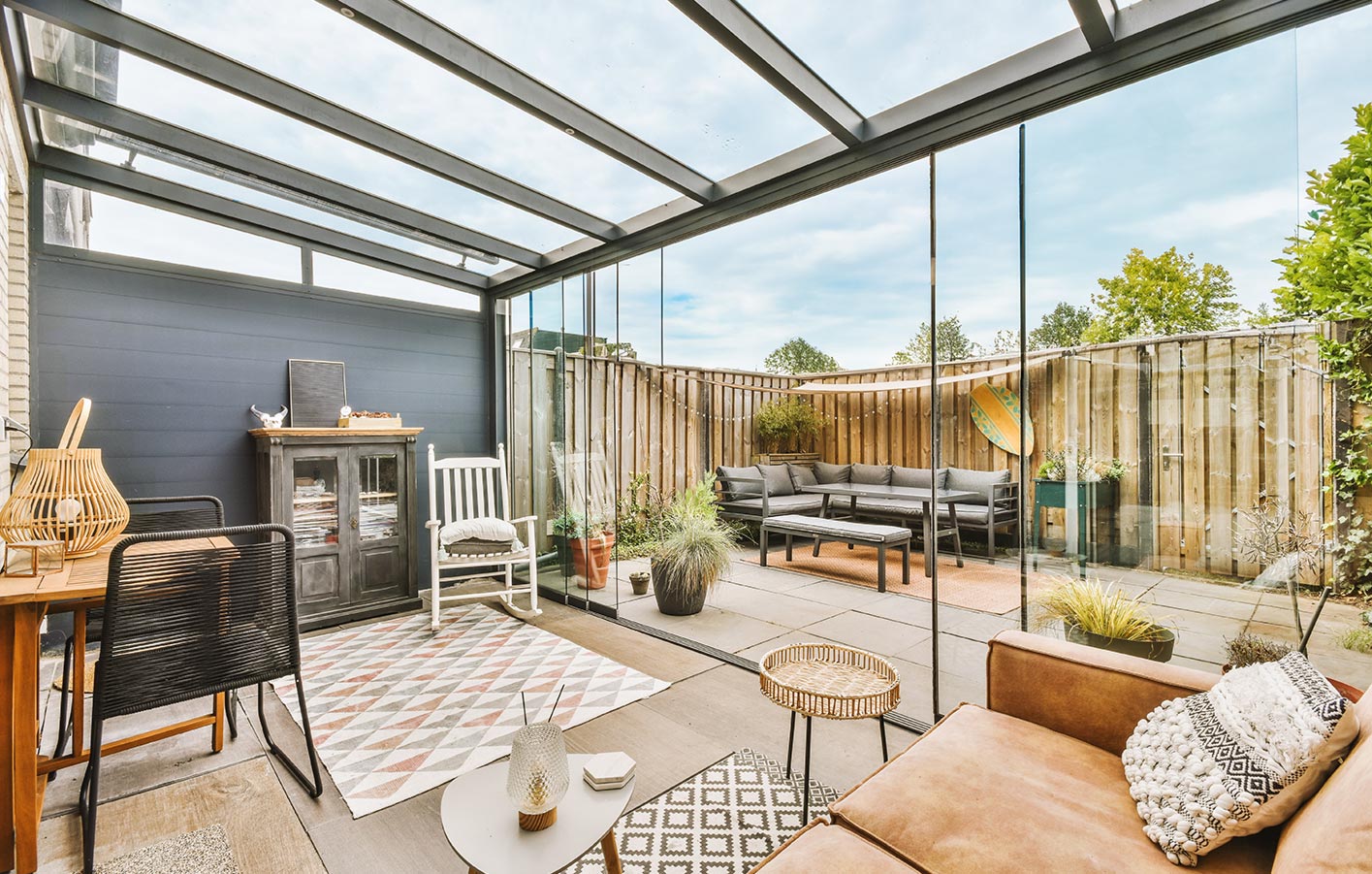 Stilvolle Erweiterung des Wohnzimmers mit einer Aluminium-Terrassenüberdachung Überdachte Terrasse als erweitertes Wohnzimmer mit Möbeln und dekorativen Elementen
